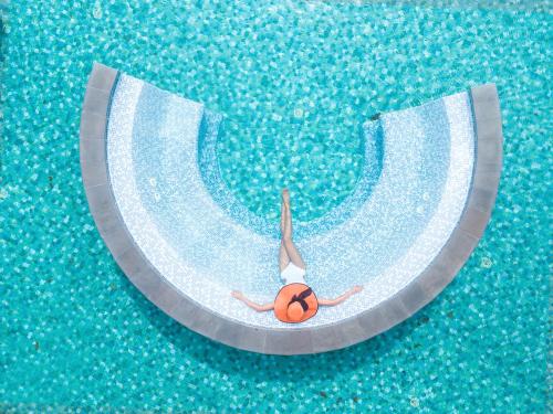 a person in a swimming pool with a ball at MGM Grand Sanya in Sanya