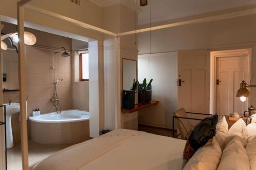 a bedroom with a bed and a bath tub at Sonnekus Boutique Hotel & Bistro in Kalk Bay