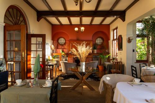 a dining room with tables and chairs and a room with red walls at Sonnekus Boutique Hotel & Bistro in Kalk Bay