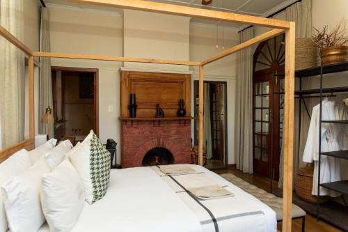 a bedroom with a bed and a fireplace at Sonnekus Boutique Hotel & Bistro in Kalk Bay
