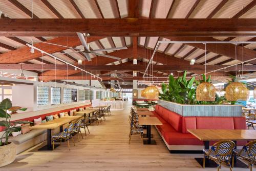 a restaurant with tables and chairs and potted plants at Sol Falco Menorca in Son Xoriguer