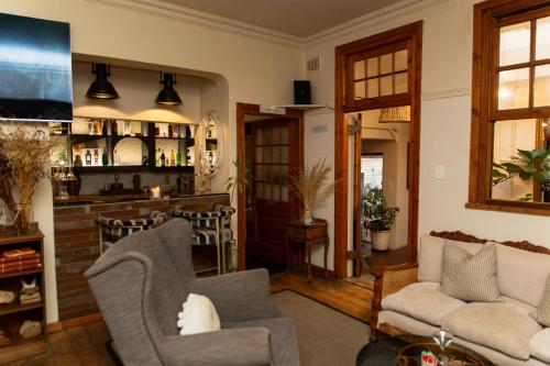 a living room with two chairs and a bar at Sonnekus Boutique Hotel & Bistro in Kalk Bay