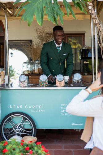 a man in a green suit standing at a food cart at Sonnekus Boutique Hotel & Bistro in Kalk Bay