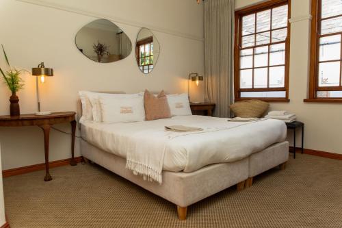 a bedroom with a large bed and a mirror at Sonnekus Boutique Hotel & Bistro in Kalk Bay