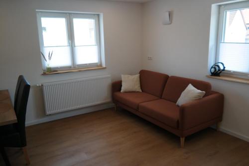a living room with a couch and two windows at Apartment 67 in Bad Neustadt an der Saale
