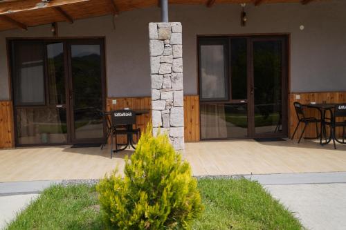 a house with a patio with tables and chairs at Hotel Hobbiton near Vardzia Caves in T'mogvi