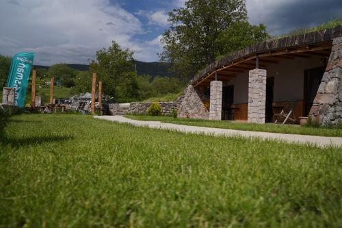 a stone building with a grassy field next to it at Hotel Hobbiton near Vardzia Caves in T'mogvi