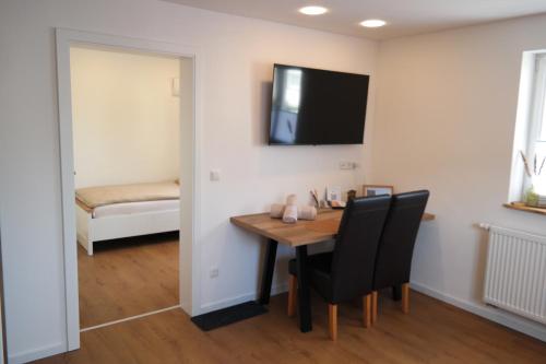 a dining room with a table and chairs and a television at Apartment 67 in Bad Neustadt an der Saale