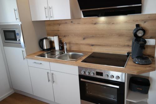 a small kitchen with a sink and a stove at Apartment 67 in Bad Neustadt an der Saale