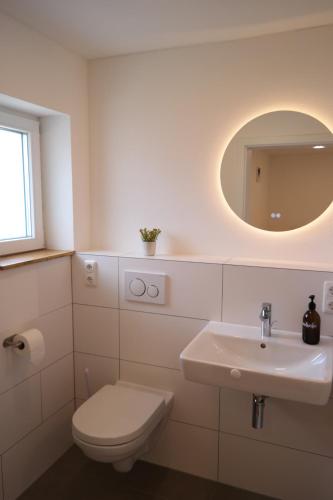 a white bathroom with a toilet and a sink at Apartment 67 in Bad Neustadt an der Saale
