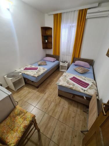 um quarto com duas camas e uma cadeira em Sobe Nedović em Budva