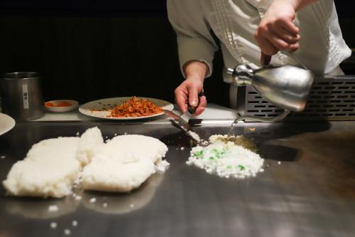 a person is preparing food in a kitchen at Marianas Beach Resort in Saipan