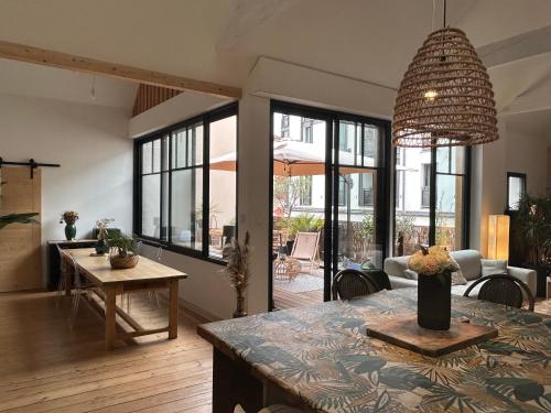 un salon avec une table et un grand lustre dans l'établissement Aloha, à Arcachon