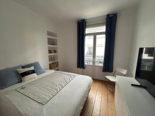 une chambre avec un grand lit et une fenêtre dans l'établissement Aloha, à Arcachon