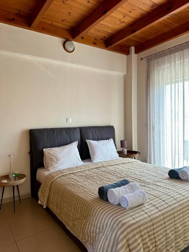 a bedroom with a large bed with towels on it at Villa Papagiorgio Luxury and Harmony in Gennadi