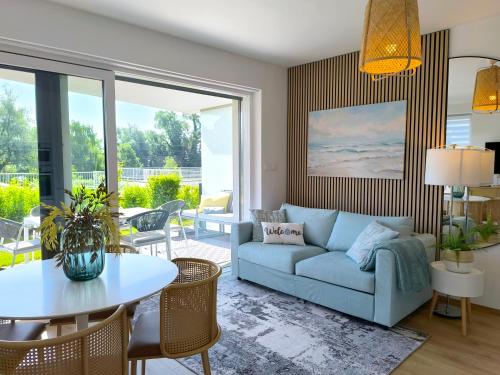 un soggiorno con un divano e un tavolo di Helikon Beach Apartment a Keszthely