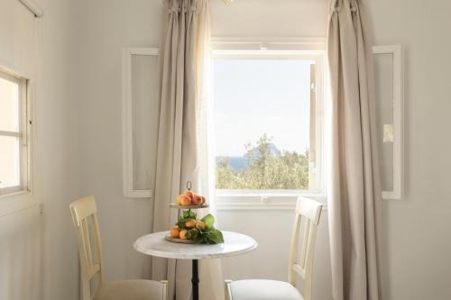 a table with fruit on it in front of a window at SPITIA VASILI in Kapsálion