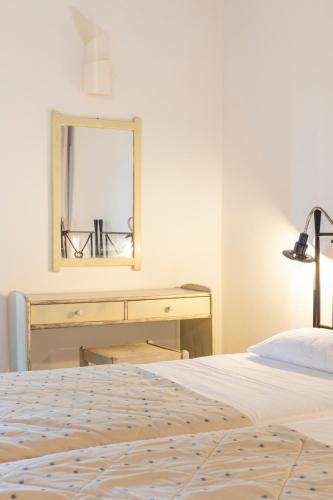 a bedroom with a bed and a dresser and a mirror at SPITIA VASILI in Kapsálion