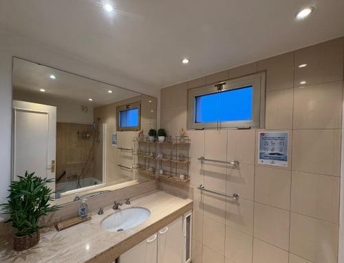 une salle de bain avec un lavabo et un miroir dans l'établissement Appartement vue & front de mer, piscines, 55M2 2Pièces, à Cannes