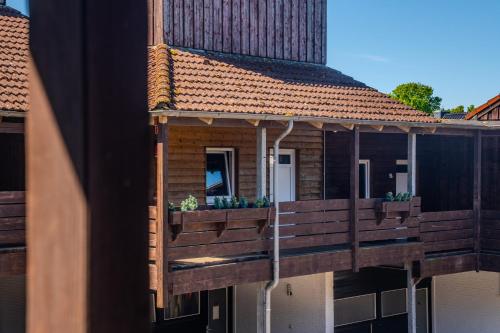 a building with a deck with potted plants on it at K 357 - Low budget Hotel in Ratekau bei Lübeck in Ratekau