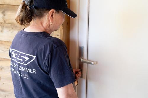 a woman opening the door to a house at K 357 - Low budget Hotel in Ratekau bei Lübeck in Ratekau