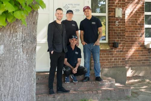 a group of men standing in front of a house at K 357 - Low budget Hotel in Ratekau bei Lübeck in Ratekau