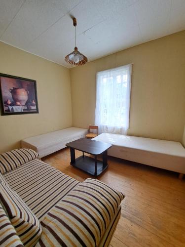 a room with two couches and a table and a window at Basanavičiaus kampelis in Palanga