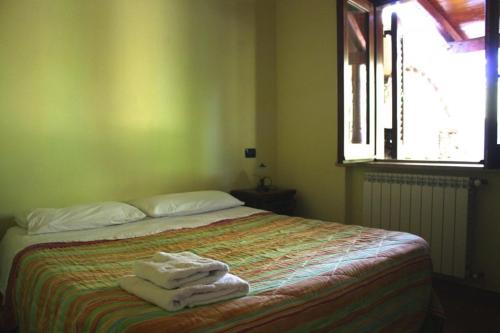 a bedroom with a bed with towels on it at Casa LiSa in Caria