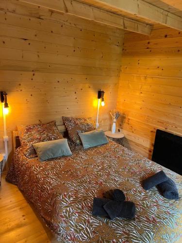 a bedroom with a large bed in a wooden room at Chalets d etangs in Beaumesnil