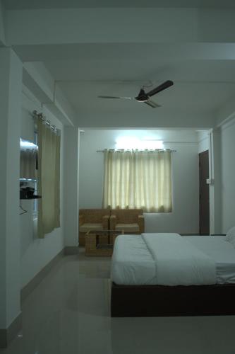 a white bedroom with a bed and a couch at Traveller's Hostel by Spirit of Adventure, Dirang in Dirang Dzong