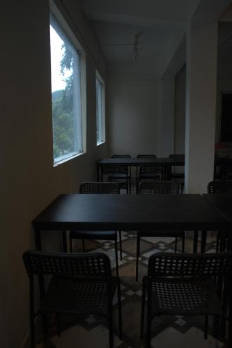 an empty room with tables and chairs and a window at Traveller's Hostel by Spirit of Adventure, Dirang in Dirang Dzong
