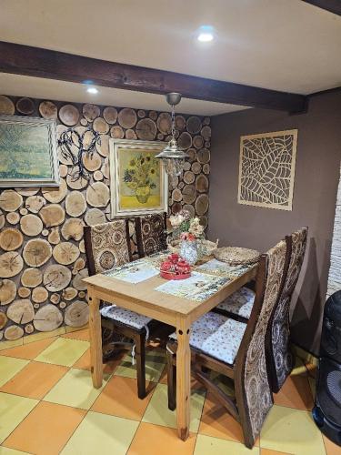 a dining room with a wooden table and chairs at Chata u rybníka - Chrastná in Osečná