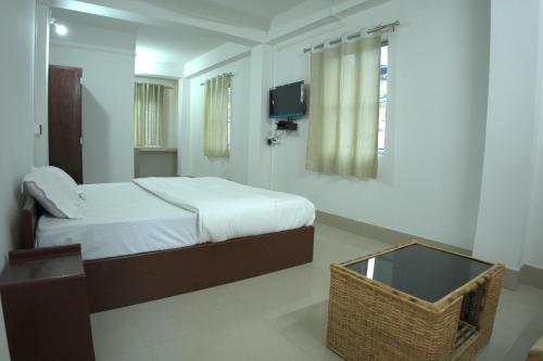 a bedroom with a bed and a television in it at Traveller's Hostel by Spirit of Adventure, Dirang in Dirang Dzong