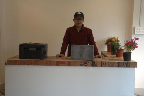 a man sitting at a table with a laptop computer at Traveller's Hostel by Spirit of Adventure, Dirang in Dirang Dzong