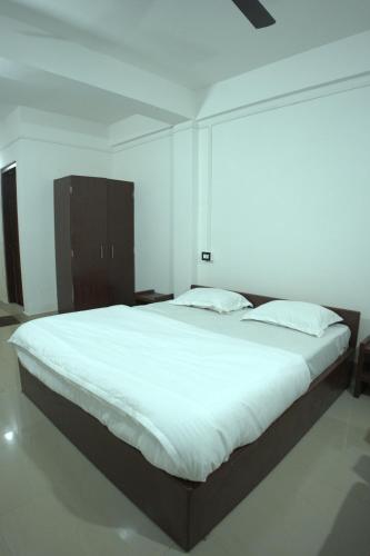 a bedroom with a large bed with white sheets at Traveller's Hostel by Spirit of Adventure, Dirang in Dirang Dzong