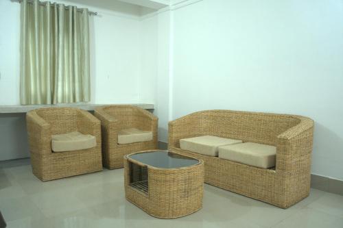 three wicker chairs and a table in a room at Traveller's Hostel by Spirit of Adventure, Dirang in Dirang Dzong