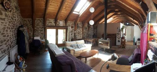 a living room with a couch and a tv at B&B Bio et écolo du Besset in Yssingeaux