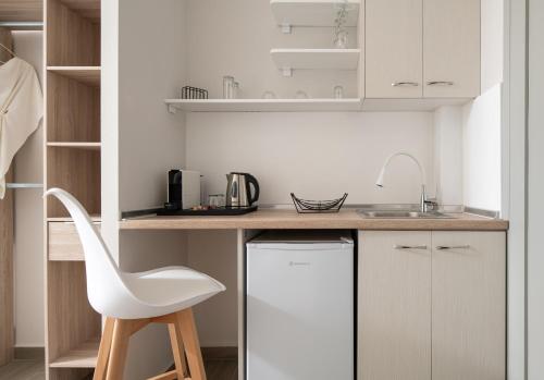 a white kitchen with a white chair and a counter at Villa Paraschou in Neos Marmaras
