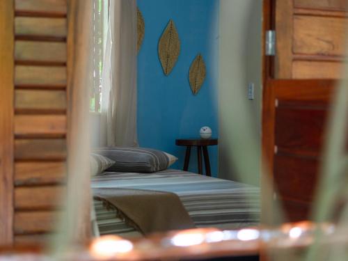 a bedroom with a bed and a blue wall at Casa de hóspedes Balibar Cumbuco in Cumbuco