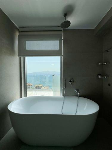 a bath tub in a bathroom with a window at Penthouse with Jackuzy in Sarandë