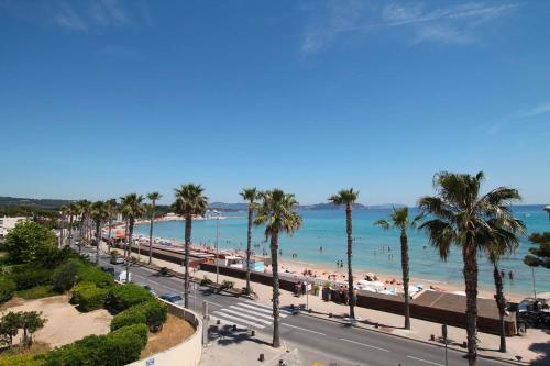 une vue sur une plage avec des palmiers et l'océan dans l'établissement magnifique T2 calme bord de mer, à La Ciotat