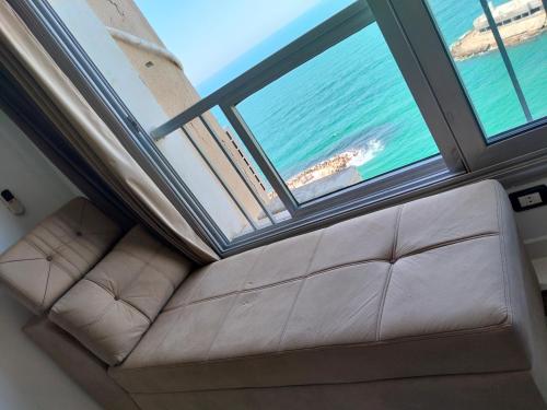 a couch in a room with a view of the ocean at Gleem Luxury Condo Direct Sea view G18 in Alexandria