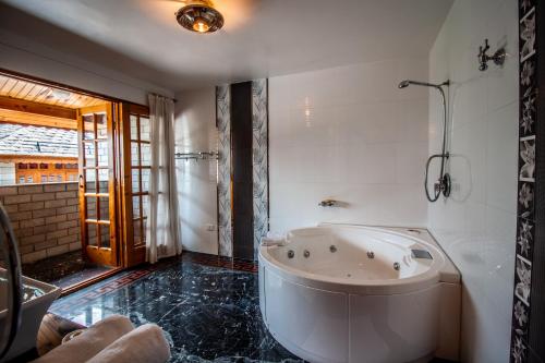 a large bathroom with a tub and a shower at Silverstone Mansions Cottages in Manāli
