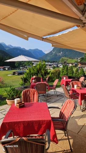 a group of tables and chairs with a red table cloth at Tourist Hotel Boehm in Schönau am Königssee