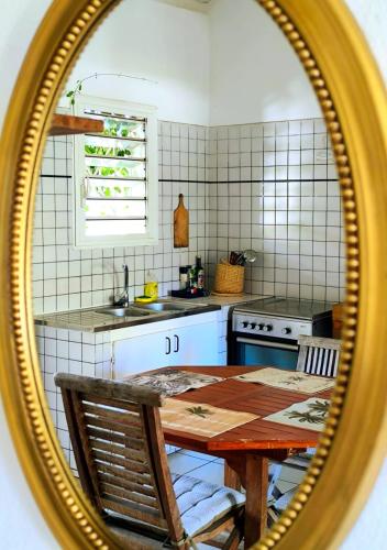 a kitchen with a wooden table in a mirror at Les zoizeaux- T2 à 100m de la plage de l'ermitage in Saint-Paul