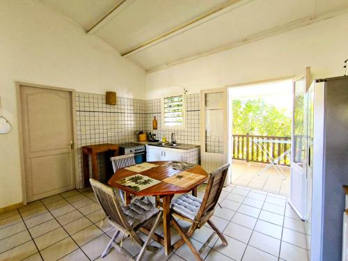a kitchen with a wooden table and chairs at Les zoizeaux- T2 à 100m de la plage de l'ermitage in Saint-Paul