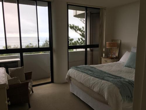 una camera da letto con un letto e vista sull'oceano di Views & Sounds of the Sea Bed & Breakfast -hosted by Deb a Coffs Harbour