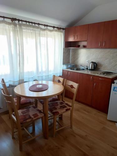 a kitchen with a table and chairs in a room at Guest House Ela in Bansko