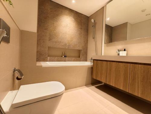 a bathroom with a toilet and a sink and a tub at Downtown Views 2 - Burj Khalifa View in Dubai