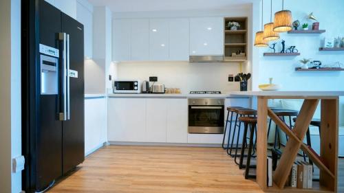 a kitchen with a black refrigerator and a table at Downtown Views 2 - Burj Khalifa View in Dubai